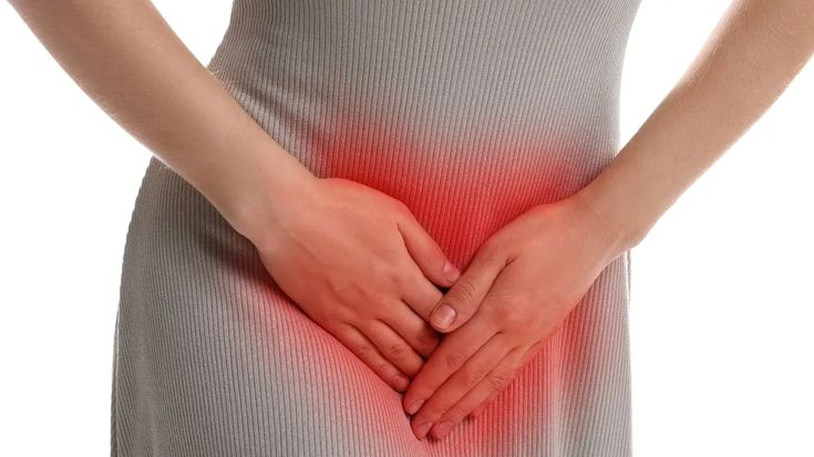 A woman holding her lower abdomen, highlighting discomfort linked to vaginal itching and irritation